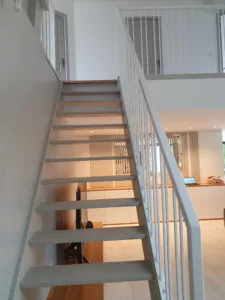 Escalier modernisé avec un garde-corps en métal noir, conçu à Garches, Saint-Cloud et Marnes-la-Coquette par Olga Chihai Dusciac.