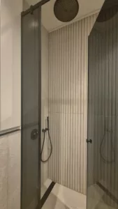 Salle de bain compacte avec douche spacieuse et meuble sur mesure en Corian – projet signé DUstudiO Interiors, Olga Chihai Dusciac