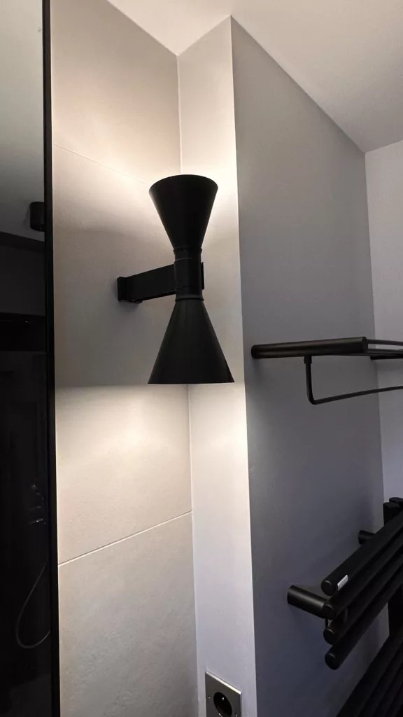 Détail d’une applique design et d’un miroir sur mesure dans une salle de bain à Saint-Cloud – Olga Dusciac architecte d’intérieur